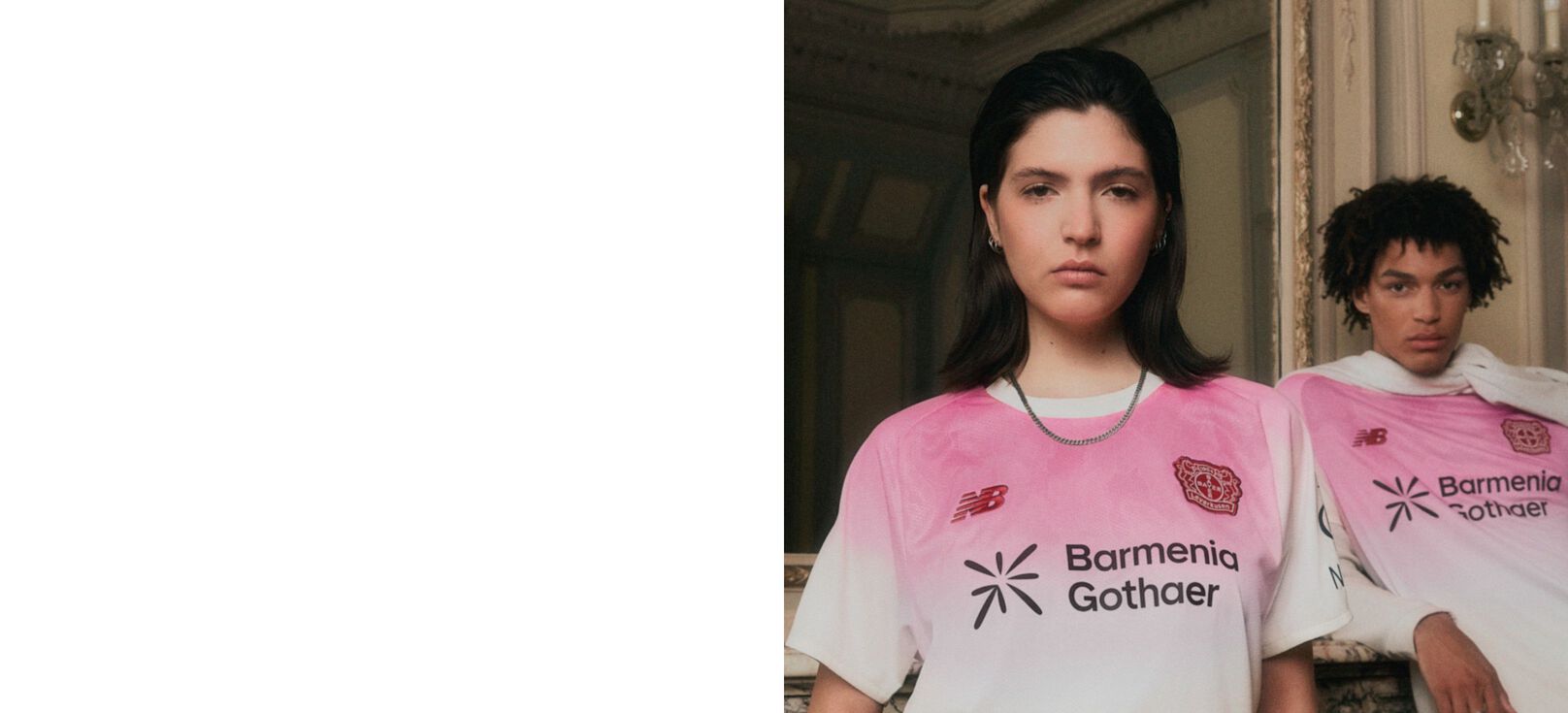 Young couple wearing pink soccer jerseys leaning up against a mirror. 